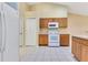 Open kitchen with wood cabinets, a microwave, and modern white appliances at 14256 Salvatierra Ln, Port Charlotte, FL 33981
