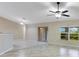 Spacious living room with neutral tile flooring, large windows, and a ceiling fan, perfect for relaxation at 14256 Salvatierra Ln, Port Charlotte, FL 33981