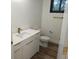Modern bathroom features white cabinetry, marble counters, a toilet, and wood laminate flooring at 14914 San Domingo Blvd, Port Charlotte, FL 33981