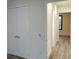 Hallway featuring wood flooring and a double door closet with gold handles at 14914 San Domingo Blvd, Port Charlotte, FL 33981