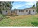 Backyard view of the home showing a wooden deck, sliding glass doors, and well-maintained grass at 14050 Blackjack Rd, Dover, FL 33527