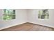 Empty bedroom with two windows providing lots of natural light and wood-look flooring at 14050 Blackjack Rd, Dover, FL 33527