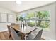 Dining room with wood table, grey chairs, and a large window view of the outdoors at 14050 Blackjack Rd, Dover, FL 33527