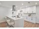 Bright kitchen with white cabinets, stainless steel hood, and a large quartz island with bar seating at 14050 Blackjack Rd, Dover, FL 33527