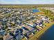 Aerial view of a residential neighborhood with a lake, featuring houses with pools and fenced yards at 8506 Hunters Fork Loop, Ruskin, FL 33573