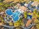 Aerial shot of a luxury community pool with a playground and clubhouse, nestled in a lush, landscaped setting at 8506 Hunters Fork Loop, Ruskin, FL 33573