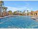 Stunning community pool with crystal-clear water, surrounded by palm trees and resort-style amenities for relaxation and recreation at 8506 Hunters Fork Loop, Ruskin, FL 33573