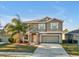 Inviting two-story home with a manicured lawn, palm tree, and attached garage at 8506 Hunters Fork Loop, Ruskin, FL 33573