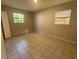 A well-lit bedroom with tile flooring and two windows that offers natural light at 3217 Deerfield Dr, Tampa, FL 33619