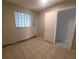 A quiet bedroom featuring a glass block window, neutral paint, and tiled flooring at 3217 Deerfield Dr, Tampa, FL 33619