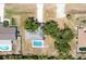 Aerial view of a property with a pool, spacious yard, and mature trees, perfect for outdoor living at 19543 Midway Blvd, Port Charlotte, FL 33948