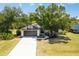 Charming single-story home with a two-car garage, mature trees, and well-maintained landscaping at 19543 Midway Blvd, Port Charlotte, FL 33948
