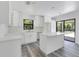 Bright kitchen featuring white cabinets, a center island, stainless appliances, and hardwood floors at 19543 Midway Blvd, Port Charlotte, FL 33948