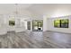 Bright living room with open floor plan, sleek gray floors, and a modern kitchen overlooking the space at 19543 Midway Blvd, Port Charlotte, FL 33948