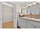 Bathroom featuring a vanity with storage, a mirror, and a walk-in closet with wire shelving at 24277 Treasure Island Blvd, Punta Gorda, FL 33955