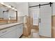 Updated bathroom featuring a modern vanity, decorative mirror, and a sliding barn door for the water closet at 24277 Treasure Island Blvd, Punta Gorda, FL 33955