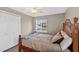 Comfortable bedroom features a ceiling fan, a window with mini-blinds, and a rattan bed frame at 24277 Treasure Island Blvd, Punta Gorda, FL 33955