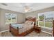 Comfortable bedroom features a ceiling fan, two windows with mini-blinds, and a rattan bed frame at 24277 Treasure Island Blvd, Punta Gorda, FL 33955