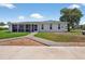 Charming single-story home showcasing a well-maintained lawn and a lush, mature shade tree at 24277 Treasure Island Blvd, Punta Gorda, FL 33955