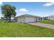 Charming single-story home featuring a green metal roof, and well-manicured lawn at 24277 Treasure Island Blvd, Punta Gorda, FL 33955