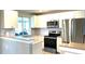 Modern kitchen featuring stainless steel appliances, granite countertops, and white cabinets at 24277 Treasure Island Blvd, Punta Gorda, FL 33955