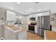 Well-lit kitchen with stainless steel appliances, including a modern refrigerator and ample countertop space at 24277 Treasure Island Blvd, Punta Gorda, FL 33955