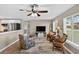 Open-concept living room featuring wood floors, comfortable seating, large windows, and a ceiling fan at 24277 Treasure Island Blvd, Punta Gorda, FL 33955
