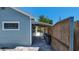 Exterior view of a blue house with a covered walkway leading to a backyard entertainment space at 6020 Illinois Ave, New Port Richey, FL 34653
