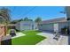 Spacious backyard with artificial grass, a detached garage and a paved area with seating, perfect for relaxing at 6020 Illinois Ave, New Port Richey, FL 34653