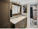 Bathroom featuring a modern vanity, decorative mirror, and tiled shower at 6020 Illinois Ave, New Port Richey, FL 34653