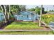 Beautifully landscaped front yard and blue exterior of a well-maintained single-story home at 6020 Illinois Ave, New Port Richey, FL 34653