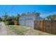 Exterior view of a detached two-car garage with white siding and a wooden privacy fence at 6020 Illinois Ave, New Port Richey, FL 34653