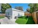 Exterior view of a detached garage with turf, a paved area, and a partial fence at 6020 Illinois Ave, New Port Richey, FL 34653