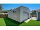 Detached garage with roll up door, adjacent to artificial grass yard and paving at 6020 Illinois Ave, New Port Richey, FL 34653