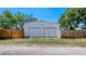 Exterior view of detached two-car garage showing access and wooden privacy fence at 6020 Illinois Ave, New Port Richey, FL 34653