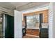 Laundry room featuring modern appliances, hardwood-style flooring, and wooden paneled wall at 6020 Illinois Ave, New Port Richey, FL 34653