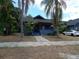 Quaint blue home with mature palm trees, a welcoming porch, and curb appeal at 834 Jackson N St, St Petersburg, FL 33705