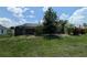 Spacious backyard with a screened-in pool area surrounded by mature trees and lush greenery at 141 Angol St, Punta Gorda, FL 33983