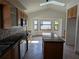 Spacious kitchen with modern appliances, granite countertops, tile backsplash, a kitchen island, and ample cabinet space at 141 Angol St, Punta Gorda, FL 33983