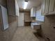Tiled laundry room featuring ample cabinet space, utility sink, and convenient storage solutions at 141 Angol St, Punta Gorda, FL 33983