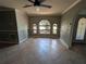 Bright living room featuring large arched windows, tile floors, and neutral paint, complemented by a ceiling fan at 141 Angol St, Punta Gorda, FL 33983