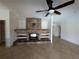 Spacious living room featuring a stone fireplace, built-in shelving, and a ceiling fan for added comfort at 141 Angol St, Punta Gorda, FL 33983
