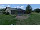 Backyard view featuring a screened-in pool area with lush landscaping and mature trees at 141 Angol St, Punta Gorda, FL 33983