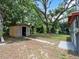 View of the backyard featuring a storage shed, lush greenery, and space for outdoor activities at 20703 Old Trilby Rd, Dade City, FL 33523
