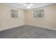Bright bedroom with two windows, neutral paint, plush carpeting, and a ceiling fan with lighting at 20703 Old Trilby Rd, Dade City, FL 33523