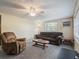 Cozy living room featuring comfortable seating, neutral carpet, and a ceiling fan at 20703 Old Trilby Rd, Dade City, FL 33523