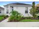 Charming single-story home with white stucco exterior, manicured landscaping, and a welcoming blue front door at 28761 Sweet Persimmon Dr, Wesley Chapel, FL 33543