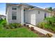 Inviting home with a white facade, manicured lawn, and a walkway leading to the bright blue entrance door at 28761 Sweet Persimmon Dr, Wesley Chapel, FL 33543