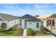 Well-maintained home featuring a classic white exterior, complemented by lush landscaping and a striking blue door at 28761 Sweet Persimmon Dr, Wesley Chapel, FL 33543