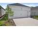 Charming home featuring a two-car garage, exterior lighting, and well-maintained landscaping at 28761 Sweet Persimmon Dr, Wesley Chapel, FL 33543